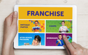 Hand holding an ipad with Crayola Imagine arts Academy franchising information on the device